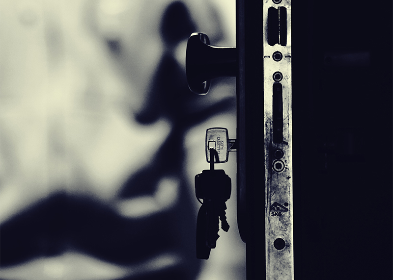 A ring of keys hangs from the lock in a door.