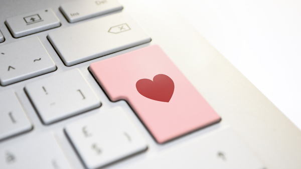 A white keyboard with a pink enter key that has a red heart.