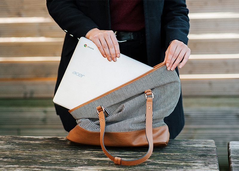 A person places a laptop inside a bag.